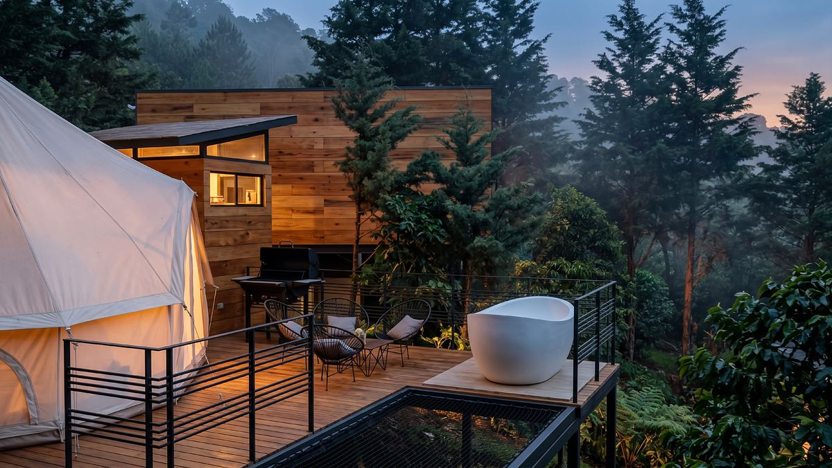 Terraza privada con tina al aire libre junto a una tienda y una cabaña