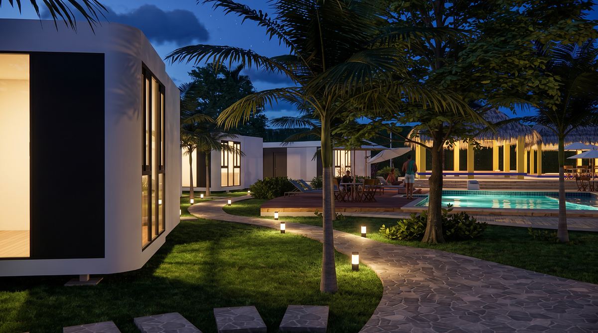 Sendero iluminado entre los módulos hacia la piscina al anochecer