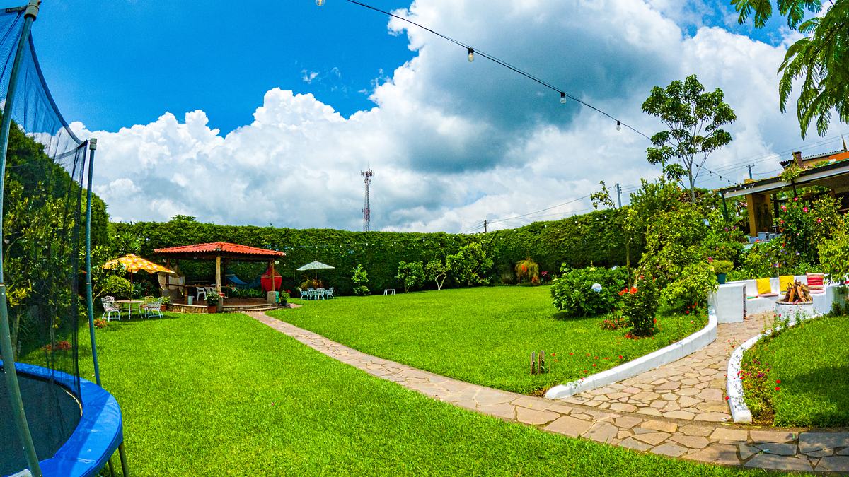 Jardín del hotel con pérgola, fogata y áreas verdes